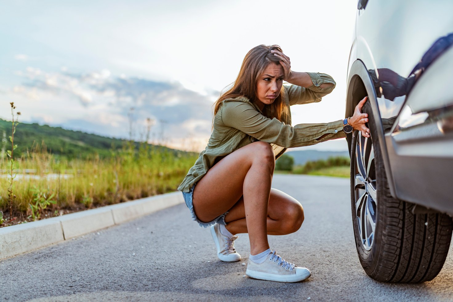 Woman with broken down car flat tire